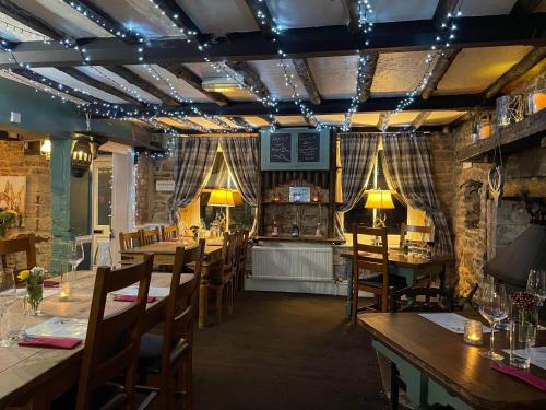 um restaurante com mesas e cadeiras num quarto em Crosskeys Inn Guest Rooms in Wye Valley em Hereford