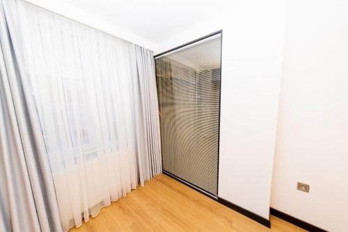a room with white curtains and a large window at Business Life Hotel & SPA Bakırköy in Istanbul