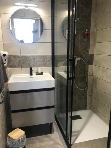 une salle de bain avec un lavabo et une douche dans l'établissement Hôtel Panoramic et des Bains, à Luz-Saint-Sauveur