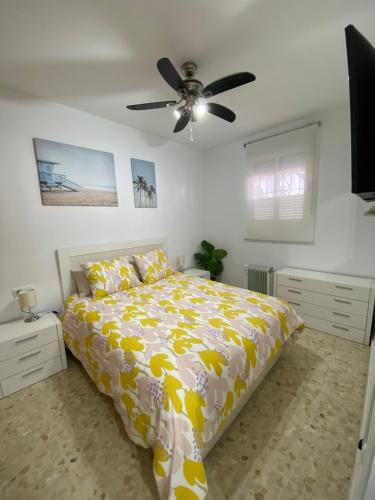 a bedroom with a bed and a ceiling fan at Precioso apartamento en el centro de Conil para familias, parejas y grupos in Conil de la Frontera