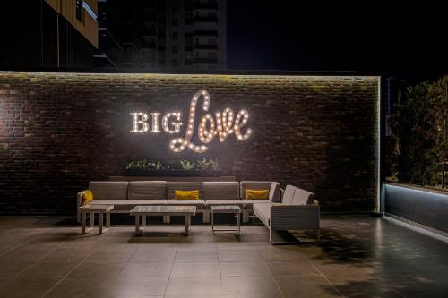 Holiday Inn Kayseri - Duvenonu في قيصري: علامة تقول الحب الكبير على جدار من الطوب