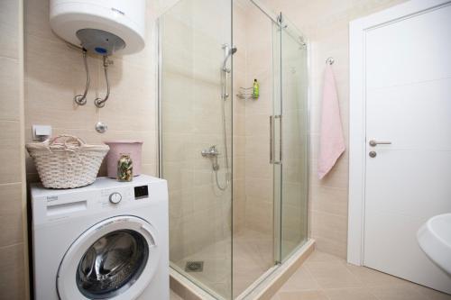 a bathroom with a washing machine and a shower at Park Apartment in Niksic in Nikšić