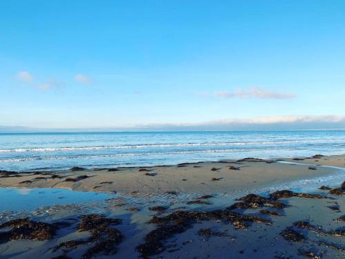 a sandy beach with the ocean in the background at Beautiful Cottage near Harlech with ocean views in Llanfair