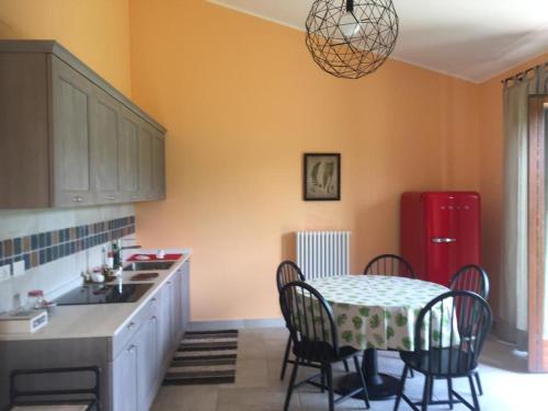 a kitchen with a table and chairs and a red refrigerator at Agriturismo Paradiso 44 in Assisi