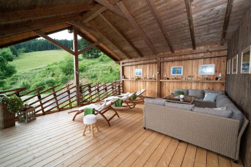 a living room with a couch and chairs on a wooden floor at Kogljahrerhütte in Wolfsberg