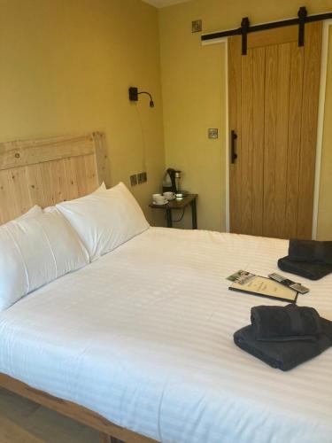 a bedroom with a white bed with a book on it at Whod Have Thought It Inn in Saltash