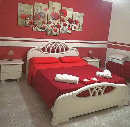 1 dormitorio con 1 cama roja y blanca y 2 mesas en Villa del Capo, en Capo Vaticano