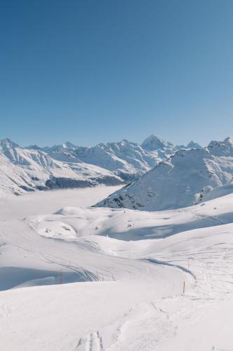 a snow covered mountain with a body of water at Hôtel Dents de Veisivi in Haudères