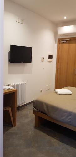 a bedroom with a bed and a television on the wall at Dal Patricano in Frosinone