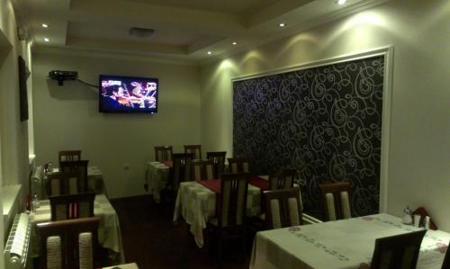 a dining room with tables and a tv on the wall at Private accommodation Lidija Rakočević in Kola&scaron;in
