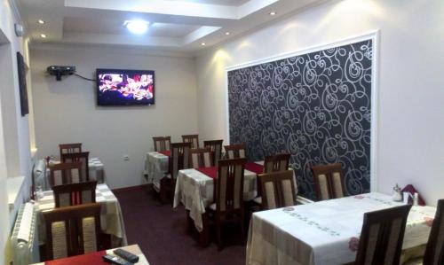 a dining room with tables and chairs and a tv on the wall at Private accommodation Lidija Rakočević in Kolašin