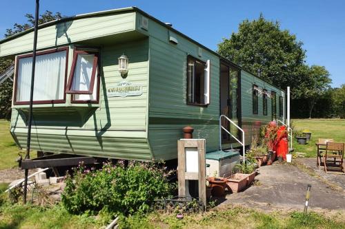 a green trailer parked in a field with a yard at 'Runway View' at Shobdon Airfield, Herefordshire in Shobdon