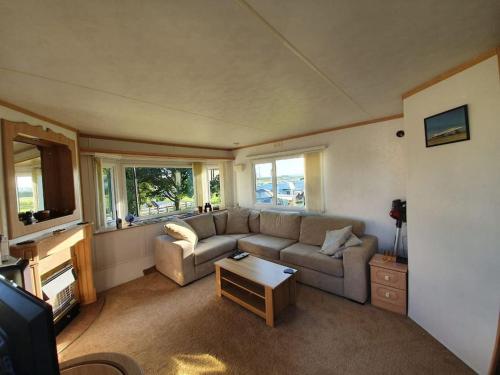 a living room with a couch and a table at 'Runway View' at Shobdon Airfield, Herefordshire in Shobdon