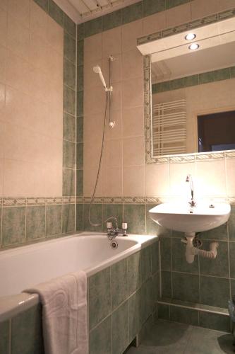 a bathroom with a sink and a bath tub and a sink at Apartament Sybiraków in Białystok