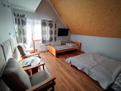 un soggiorno con letto e divano di Agroturystyka u Haliny a Kamesznica