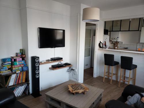 un salon avec une télévision sur un mur dans l'établissement Bel appartement, à Boulogne-sur-Mer