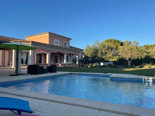 une piscine devant une maison dans l'établissement Villa et maisonnette provençales, à Carpentras
