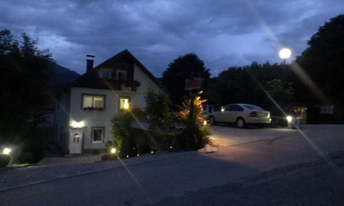 a house with a car parked in a parking lot at night at Private accommodation Lidija Rakočević in Kolašin