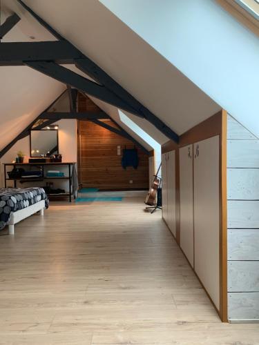 an attic room with a bed and a tv at Chambre en campagne in Parence