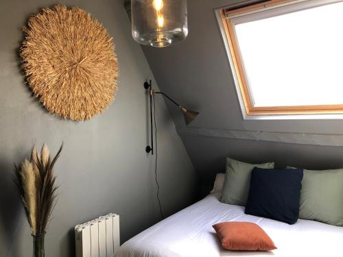 une petite chambre avec un lit et une fenêtre dans l'établissement La maison, à Vittefleur