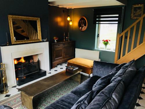 un salon avec un canapé et une cheminée dans l'établissement La maison, à Vittefleur