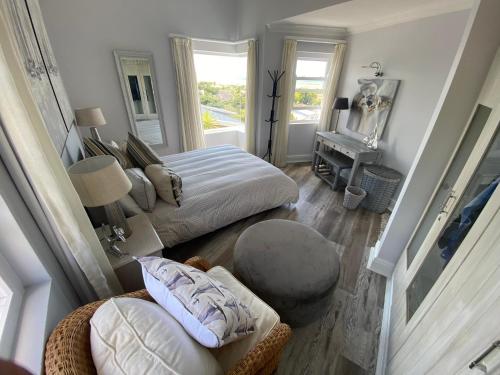 a bedroom with two beds and a chair and a table at Lasalle holiday home (Sun, Beach, Views, Fun for everyone!) in Plettenberg Bay
