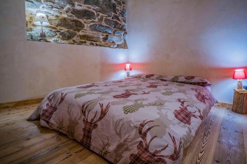 a bedroom with a bed with a comforter and two lamps at Rascard Monterosa in Champoluc