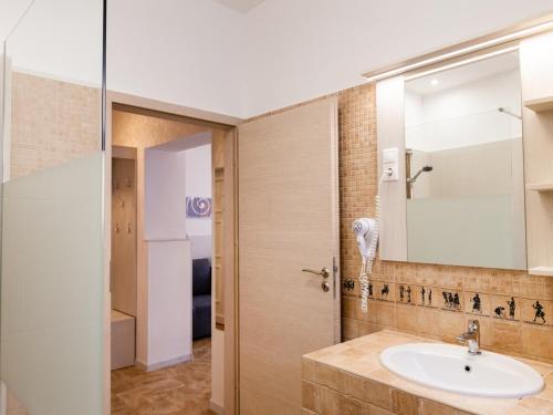 a bathroom with a sink and a mirror at Mátyás Apartmanok in Hajdúszoboszló