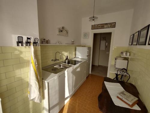 a kitchen with a sink and a refrigerator at Casa MaCrì Biella in Biella