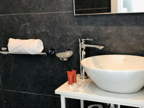 a bathroom with a white sink and a black wall at Apartments by Sliema promenade and beach in Sliema