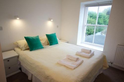 a bedroom with a large bed with towels on it at Arrandale House in Douglas