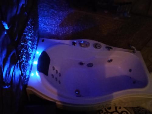 a white bathtub with blue lights on the floor at To Konaki in Synikia Mesi Trikalon