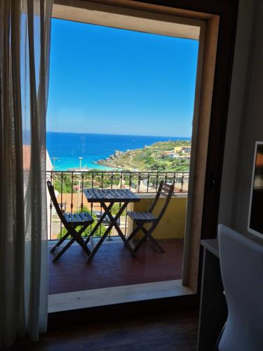 a table and chairs on a balcony with a view of the ocean at Rena Bianca Suite by La Contessa in Santa Teresa Gallura
