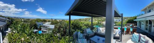 a balcony of a house with a view of a city at Lasalle holiday home (Sun, Beach, Views, Fun for everyone!) in Plettenberg Bay