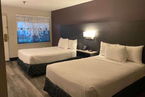 a hotel room with two beds and a window at La Quinta Inn by Wyndham Bakersfield South in Bakersfield