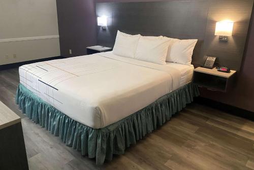 a large bed with white sheets and pillows in a hotel room at La Quinta Inn by Wyndham Bakersfield South in Bakersfield