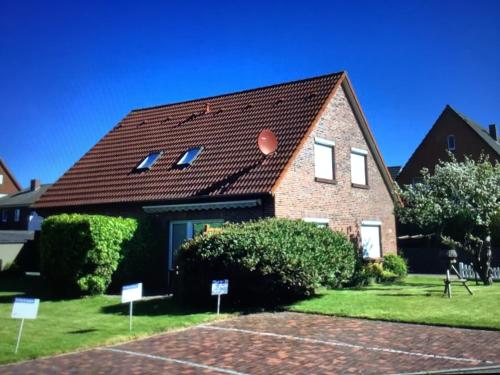 una casa de ladrillo con techo marrón en Sommerbrise 1, en Norddeich