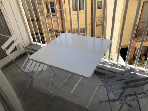 a white table and a chair on a balcony at Apartments by Sliema promenade and beach in Sliema