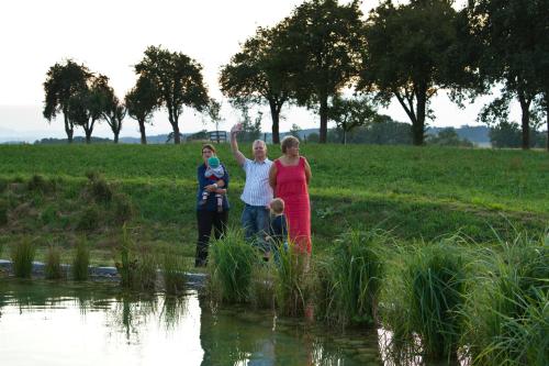 two women and a child standing by the water at Gestehof Hetzenberg in Haag