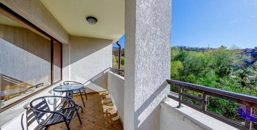 a balcony with a table and chairs on it at Troyan Plaza Hotel in Troyan