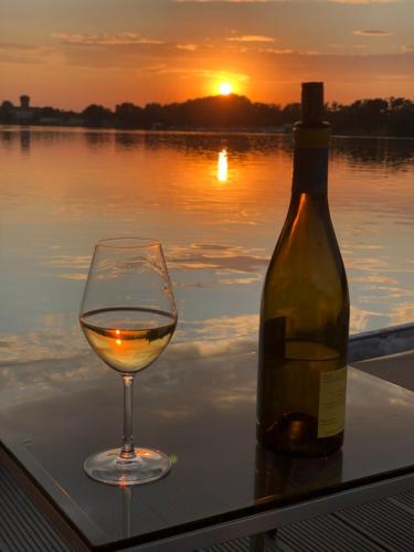 a glass of wine next to a bottle of wine at Basalt Lodge am Lehnitzsee in Oranienburg