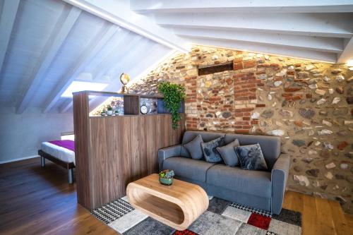 a living room with a couch and a stone wall at Loft Roby in Peschiera del Garda