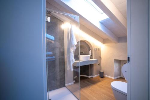 a bathroom with a glass shower with a toilet at Loft Roby in Peschiera del Garda