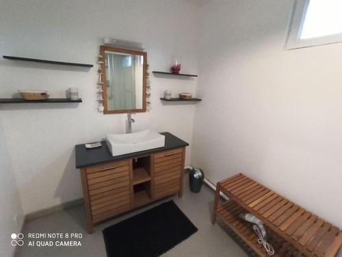 a bathroom with a sink and a mirror and a bench at Gite HELSEBAN - Maison à 3 minutes de la mer dans résidence privée in Friaucourt