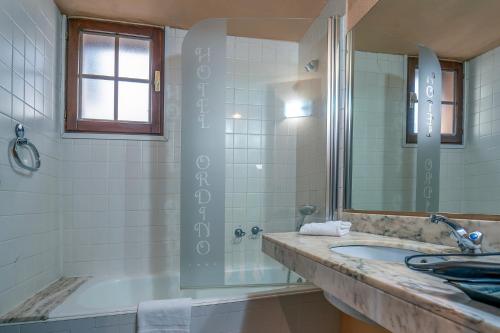 a bathroom with a shower, sink, and tub at Hotel Ordino in Ordino