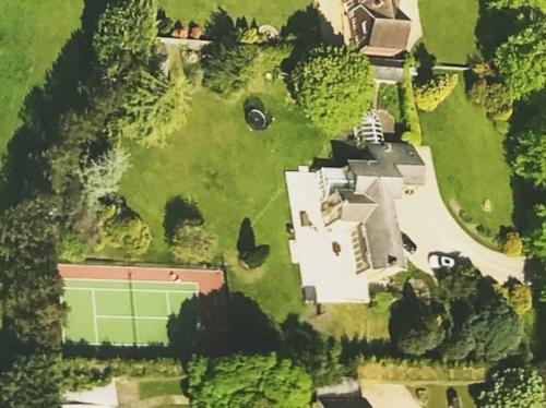 an aerial view of a house with a tennis court at Stunning Oxfordshire 5 Bedroom House in 2 acres in Aston Rowant