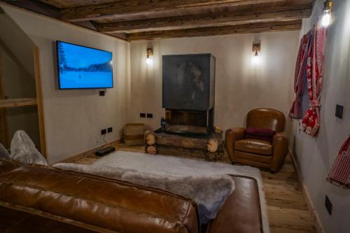 a living room with a couch and a flat screen tv at Rascard Monterosa in Champoluc