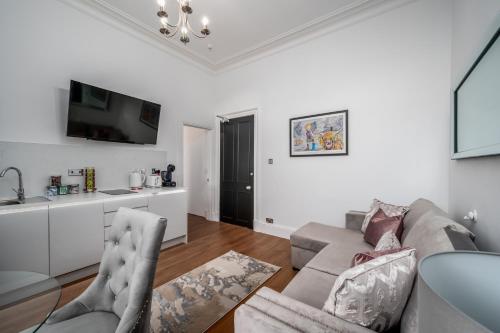 a living room with a couch and a kitchen at Casa Fresa - Orchar Suites in Broughty Ferry