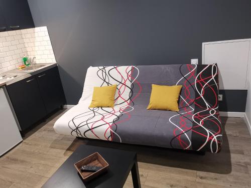 ein Wohnzimmer mit einem Sofa und zwei gelben Kissen in der Unterkunft Studio cosy au pied du METRO FLACHET in Villeurbanne