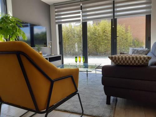 - un salon avec un canapé et une table en verre dans l'établissement Logement 80 m2 avec terrasses entre les deux abers, à Landéda